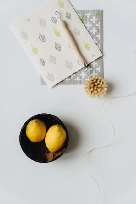 A clean and organized home office desk with a cleaner bottle and sponge, emphasizing simplicity and functionality.